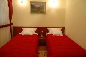 克拉列沃特诺格拉德酒店的小客房内的两张床,配有红色床单