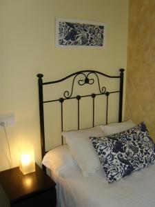圣地亚哥－德孔波斯特拉PR坦布雷旅馆的一张带枕头的床和一张桌子上的台灯