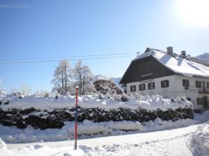黑马戈尔Schullerhof的雪覆盖的房子,前面有旗帜