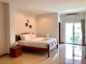 华欣班约克哈尼酒店的一间卧室设有一张床和一个大窗户