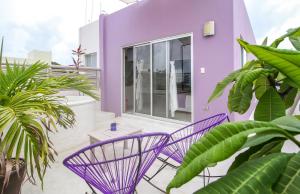 图卢姆双子座别墅精品公寓式酒店的紫色房子,阳台上配有两把紫色椅子