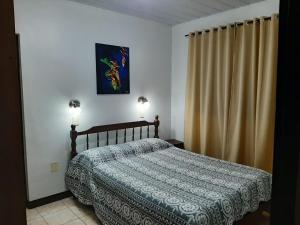 伊瓜苏港Hotel Mola的一间卧室配有床和两盏灯