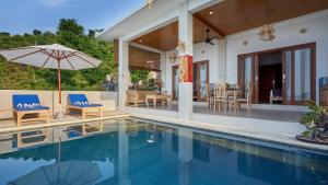 艾湄湾Villa Aska的房屋旁的游泳池配有椅子和遮阳伞