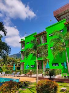高兰兰达莫拉克度假酒店的一座绿色建筑,种植了棕榈树,设有游泳池