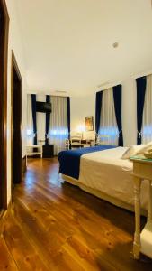 巴利亚多利德巴黎旅馆的一间卧室配有一张带蓝色窗帘的大床