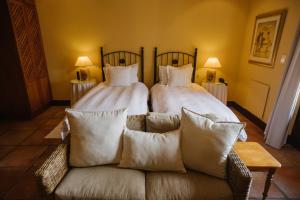 Tokai茂林旅舍的一间卧室配有两张床和一张带枕头的沙发。