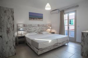 库基尼坎尼奥Evina Rooms & Suites的一间卧室设有一张大床和一个窗户。