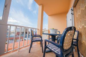 塔拉哈勒赫Tarajalejo Sun & Relax的阳台配有桌椅。
