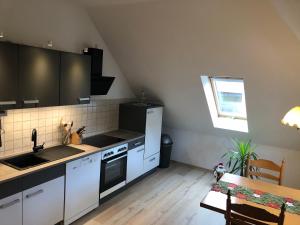 哥达Liebetrau Apartment的厨房配有白色橱柜、水槽和桌子