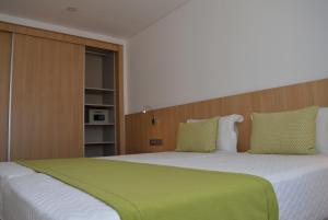 圣玛丽亚Hotel Da Luz的一间卧室配有一张带绿毯的大床