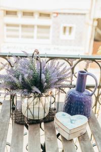 米兰德拉Dona Fina Guest House的一张长凳,上面有蓝色花瓶和鲜花
