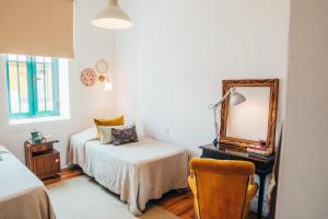 米兰德拉Dona Fina Guest House的一间卧室配有一张床、镜子和椅子