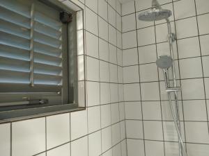 克拉伦代克红棕榈度假村的白色瓷砖浴室设有淋浴和窗户
