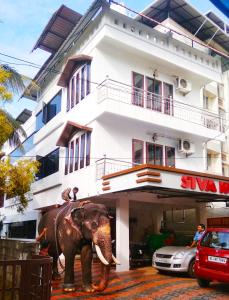 古鲁瓦尤尔Shiva Inn的站在建筑前的象