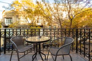 第比利斯Hotello的阳台配有桌椅和围栏