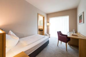 拉伊韦斯Hotel CampingPark Steiner的配有一张床和一张书桌的酒店客房