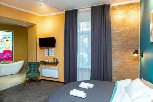第比利斯Hotello的酒店客房设有一张床和一间带浴缸的浴室。