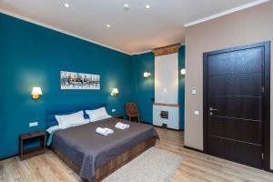 第比利斯Hotello的一间卧室设有一张床和蓝色的墙壁