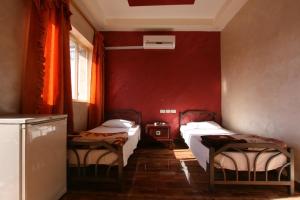 安曼Erasmus Student House By Sunrise Hostel的一间设有两张床和红色墙壁的客房