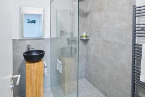 汉诺威City Apartments Hannover的一间带水槽和玻璃淋浴的浴室