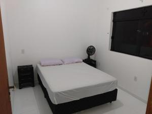 帕罗卡Apartamentos Praia do Sonho的一间卧室配有一张床和一台平面电视