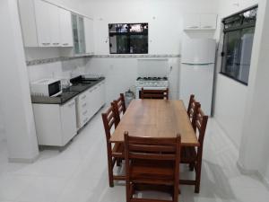 帕罗卡Apartamentos Praia do Sonho的厨房配有木桌和椅子