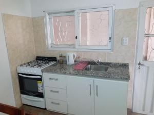 圣拉斐尔Departamento Colón 1的厨房配有水槽、炉灶和窗户。