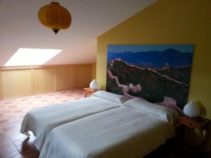 Trescasas卢拉尔卡萨德尔特尔提力法罗酒店的一间卧室设有两张床,墙上挂着一幅画