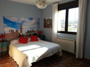 Trescasas卢拉尔卡萨德尔特尔提力法罗酒店的一间卧室配有一张带红色枕头的床