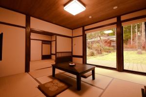 高野山高野山 宿坊 常喜院 -Koyasan Shukubo Jokiin-的客房设有桌子和大窗户。