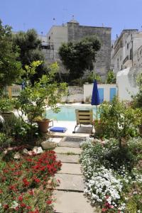 奥斯图尼阿尔塔维拉大厦公寓的一个带长凳和鲜花的花园和一个游泳池