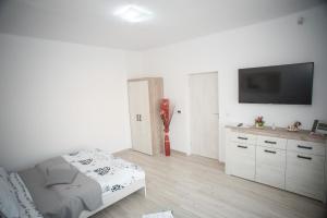 锡比乌Apartament LA MAL的白色的客房配有床和平面电视。