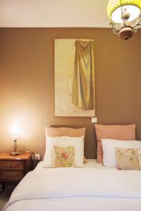 雅典雅典卫城雅典娜别墅 的卧室配有白色的床和墙上的绘画作品