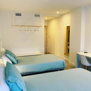 蒙蒂霍Hotel Gran Sol De Extremadura的客房设有两张床和水槽。