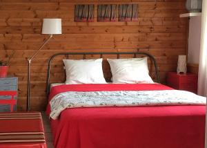 布科·莱斯白老城Le Studio Rouge de la Gare的一间卧室配有一张红色的床和木墙