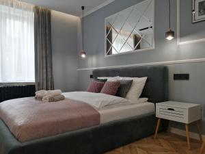 琴斯托霍瓦Apartament LUCY - ścisłe centrum Częstochowy的卧室配有一张带粉红色枕头的大床