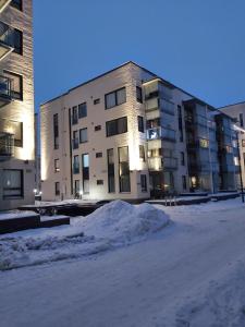 罗瓦涅米Aurora Haven Rovaniemi Modern DT Apartment -Self Check-In & Free Wifi-的前面有雪的大建筑