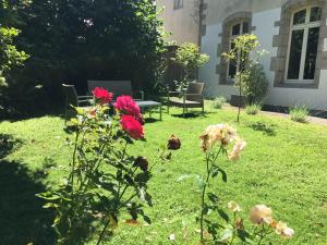 坎佩尔Tourisme et Affaires Quimper + parking privé, wifi, jardin的花园种有鲜花,配有桌椅