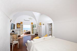波西塔诺卡萨佩普宾馆&别墅的一间白色的卧室,配有床和客厅