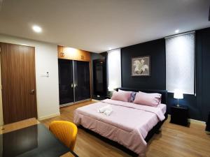 峇都丁宜Batu Ferringhi Gold Pearl Luxury Homestay Near Beach With Intex Pool的卧室配有一张带粉红色枕头的大床