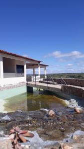 特里温福Pousada Pedra do Sossego的水体上方有桥的房子