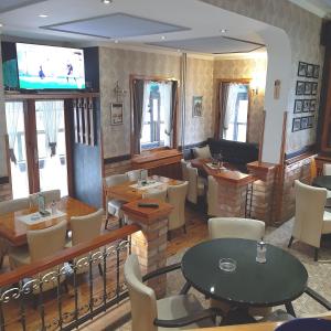 新瓦罗什Guest House Bona Fides的餐厅设有桌椅和平面电视。