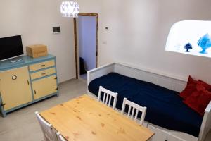 莫诺波利Amalfi Pool Suite - Puglia Mia Apartments的一间卧室配有一张床、一张桌子和一台电视。
