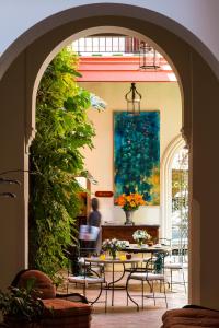 塞维利亚拉斯卡萨斯埃尔阿雷纳酒店的通往带桌椅的庭院的拱门