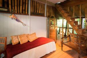 罗索Cocoa Cottage的一间卧室设有一张床和木制楼梯。
