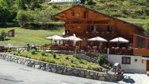 RoubionLe Chalet, chambres d hôtes, petit déjeuner inclus的前面有桌子和伞的建筑