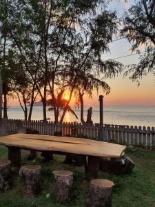 林信Baansukhita的一张木制野餐桌,背面是日落