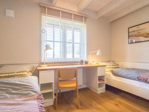 洛默Villa-Holzreich的一间卧室配有书桌、床和窗户。