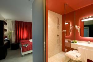 比萨圣拉涅尼酒店的一间带红色墙壁的浴室和一间带淋浴的浴室