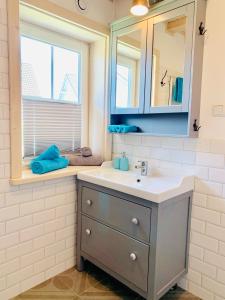 赖因伯伦Sunny Corner Holiday Apartment的一间带水槽和镜子的浴室